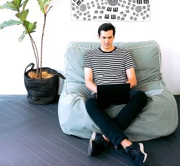 man sitting on a sofa chair on a laptop