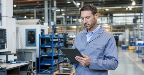 manufacturer on the shop floor holding an ipad