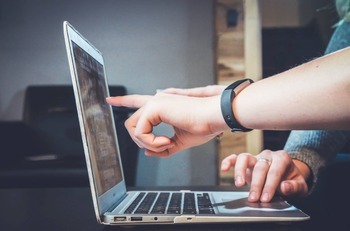 worker pointing at a laptop screen